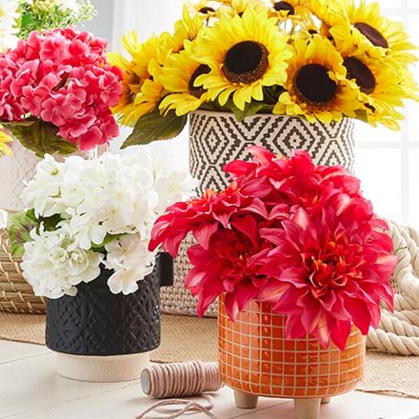 faux flowers in black, orange and white containers